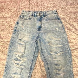 Faded light blue denim jeans and distressed and the brand is ”American Eagle”.